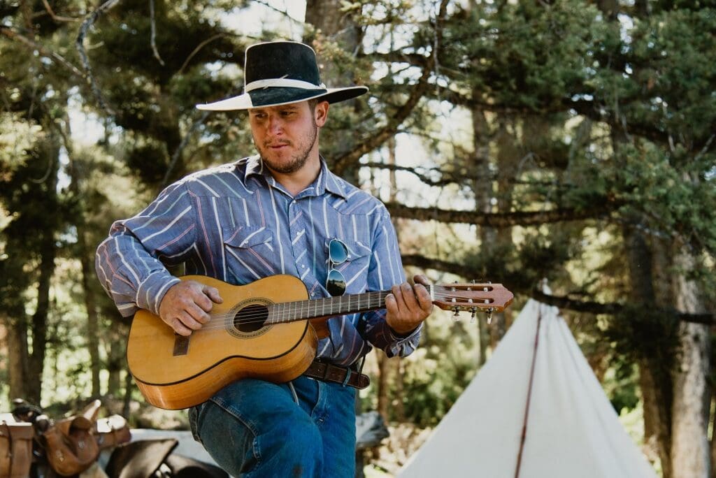 Image of range rider Jeremiah playing his guitar | where to find grass fed beef near me