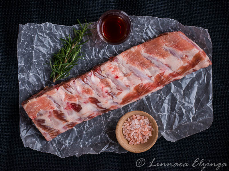 Raw pastured pork baby back ribs with sea salt and rosemary. 