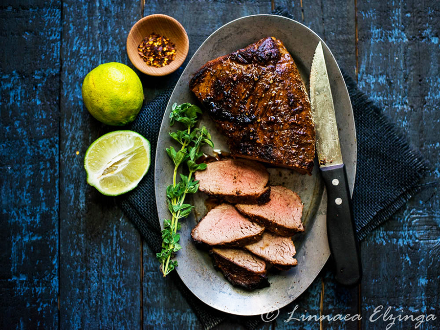 Sliced grilled tri tip roast with lime and basil garnish. 