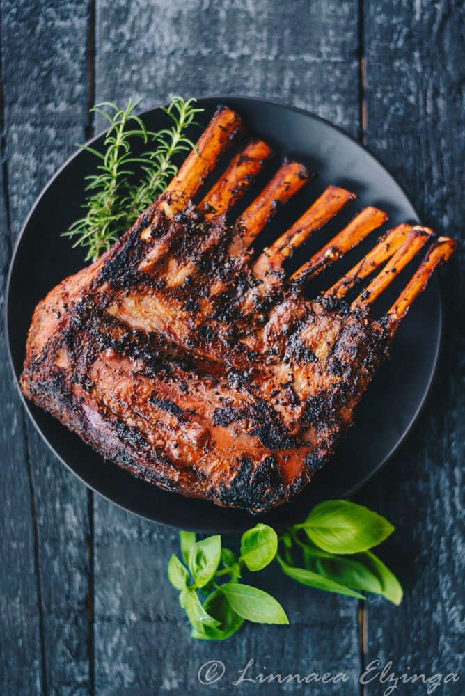 Whole grilled rack of lamb with rosemary garnish. 