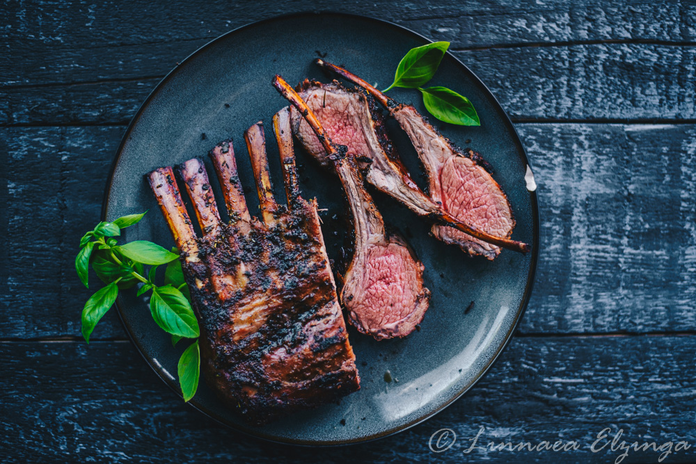 Grilled rack of lamb sliced on a plate with garnish. 