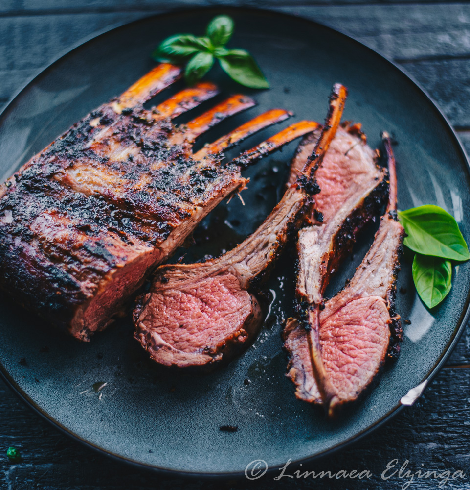 Grilled rack of lamb pieces with garnish, closeup. 