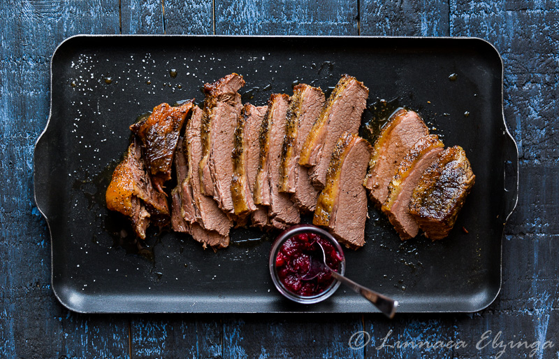 Sliced brisket roast with cranberry sauce on the side.