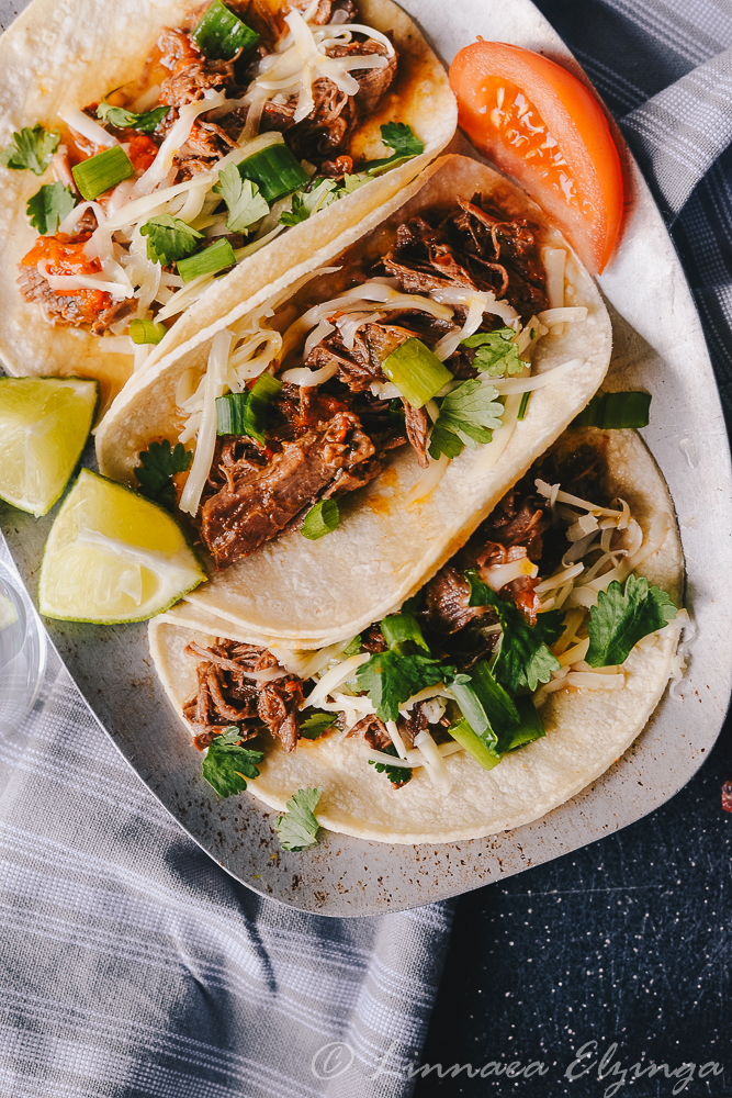 Mexican Barbacoa rump roast shredded over tacos with cilantro garnish. 