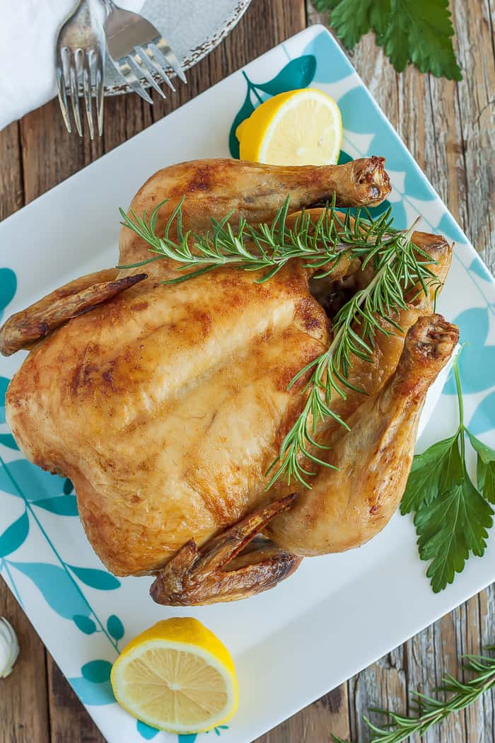 Paleo whole roast chicken with lemon garnish. 